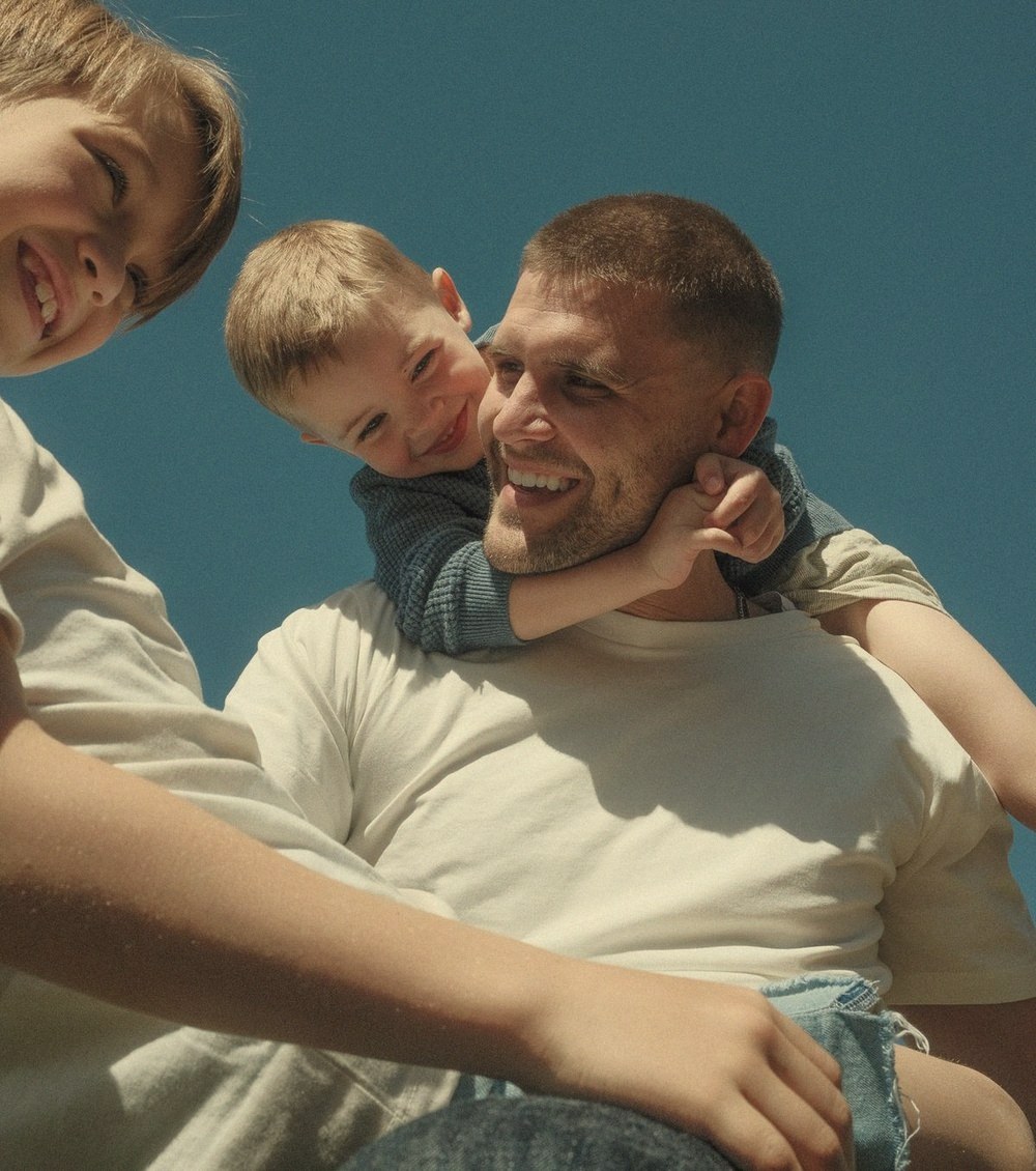 A father laughing with his two kids