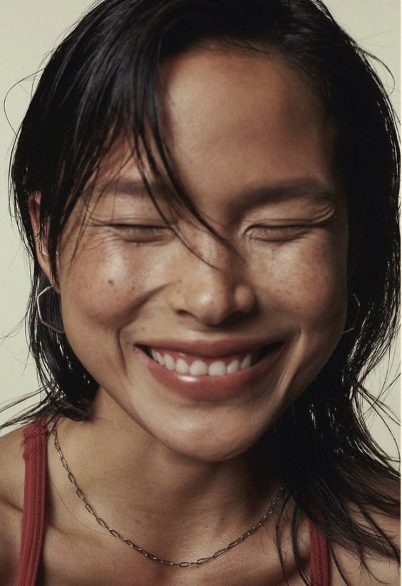 A woman laughing with her eyes closed