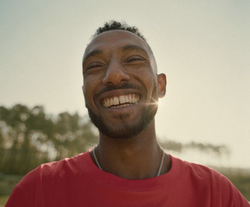 A man smiling outdoors in the sun